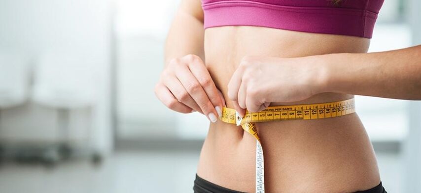Une fille mesure son tour de taille